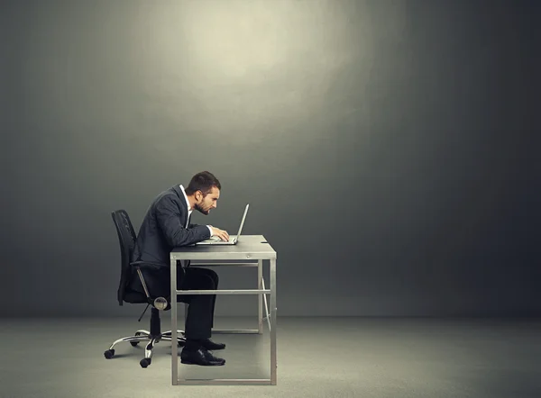 Businessman working with laptop in the dark room — Stock Photo, Image