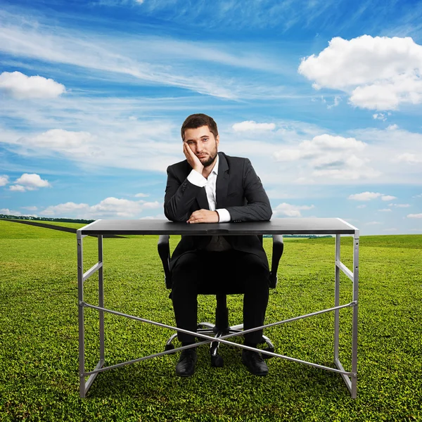 Trauriger Geschäftsmann sitzt am Tisch — Stockfoto