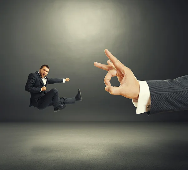 Businessman kicking, big hand flicking — Stock Photo, Image