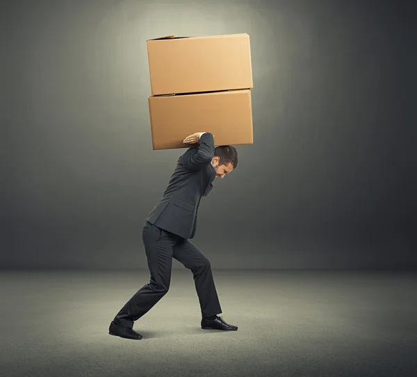 Tired young businessman with boxes — Stock Photo, Image