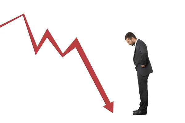 Man looking at red downturn graph — Stock Photo, Image