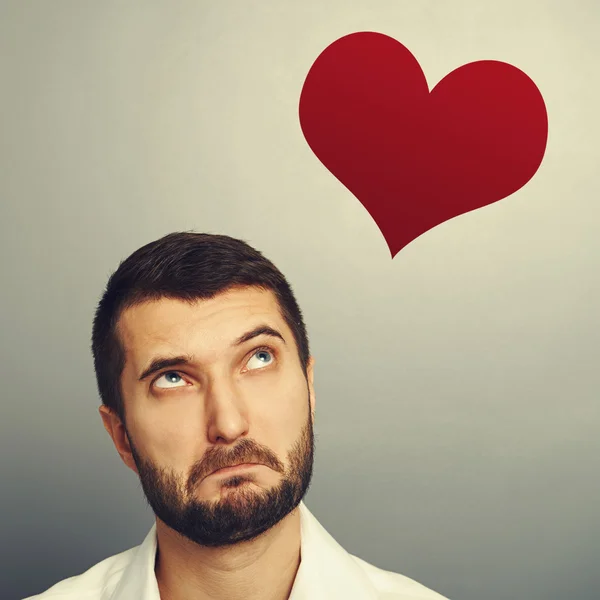 Man looking up at red heart — Stock Photo, Image