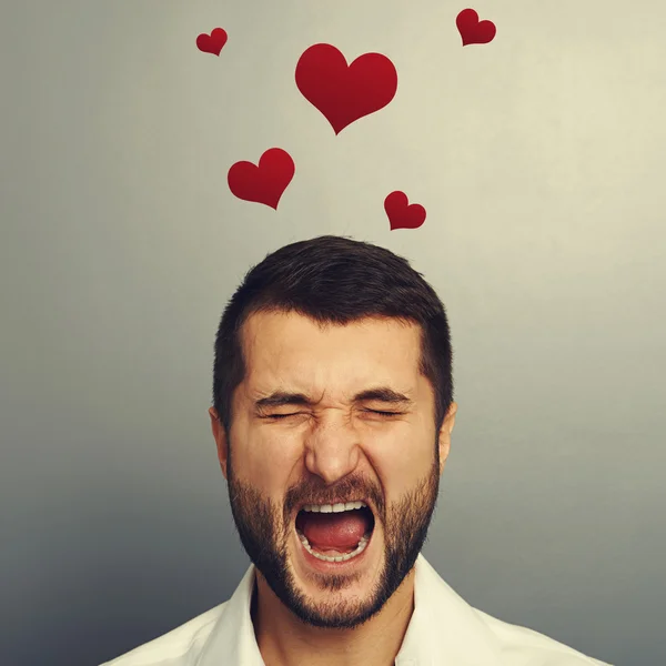 Screaming man with red hearts — Stock Photo, Image