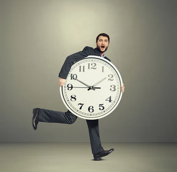 Man holding big clock and running — Stock Photo, Image