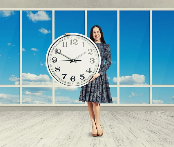 Mujer sosteniendo gran reloj, sonriendo — Foto de Stock