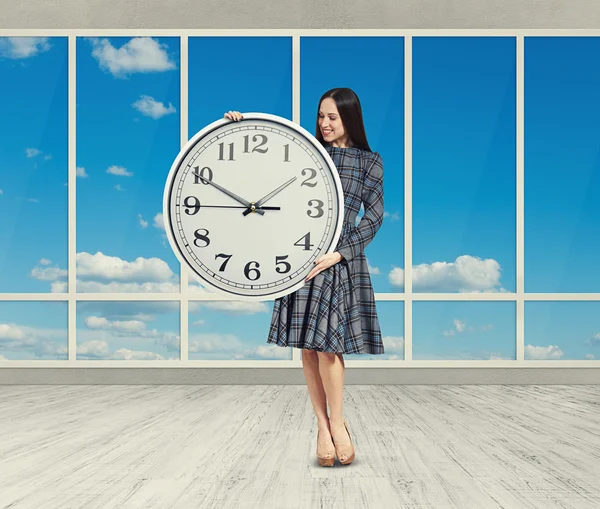 Frau blickt auf große Uhr — Stockfoto