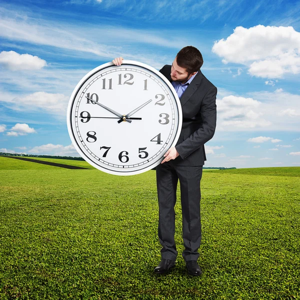 Hombre mirando el reloj grande al aire libre Imagen de stock