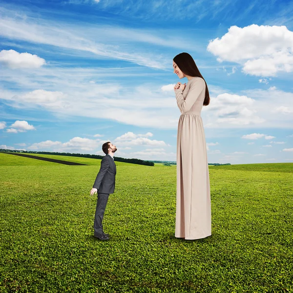 Beautiful woman looking at small man — Stock Photo, Image