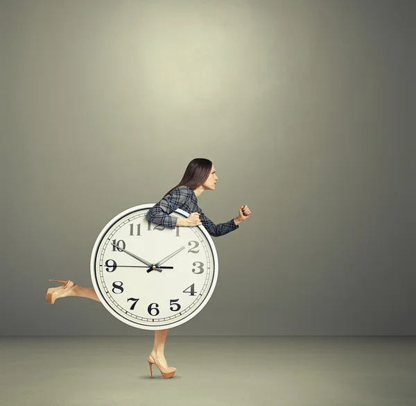 Frau hält große Uhr und läuft — Stockfoto