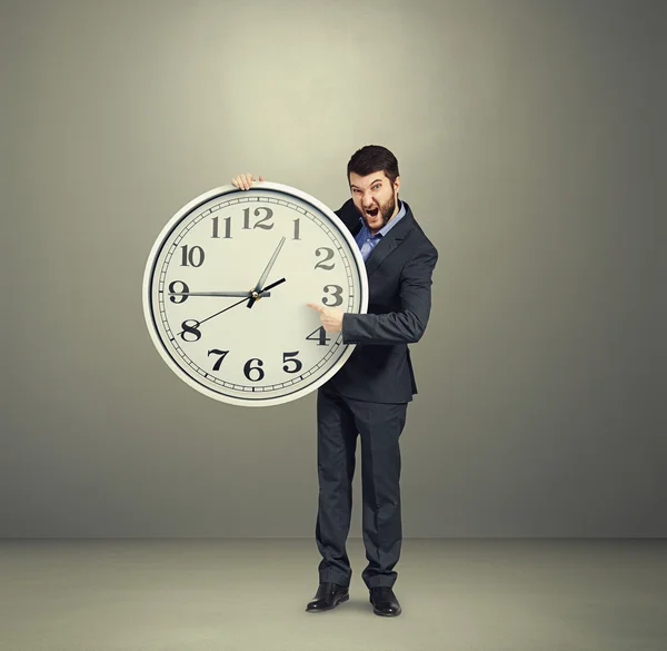 Hombre de negocios sosteniendo gran reloj blanco — Foto de Stock