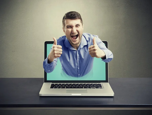 Screaming happy man got out of the laptop — Stock Photo, Image