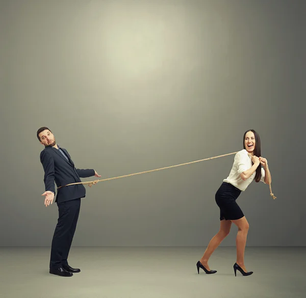 Risueño mujer arrastrando hombre en perplejidad —  Fotos de Stock