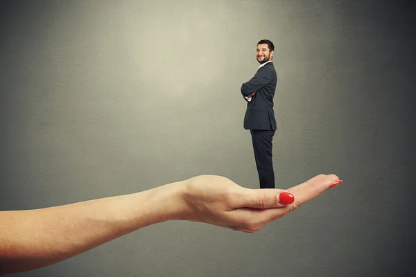 Palm holding small smiley businessman — Stock Photo, Image