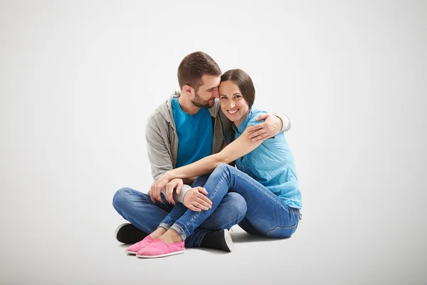 Jong paar in liefde zitten op de vloer — Stockfoto