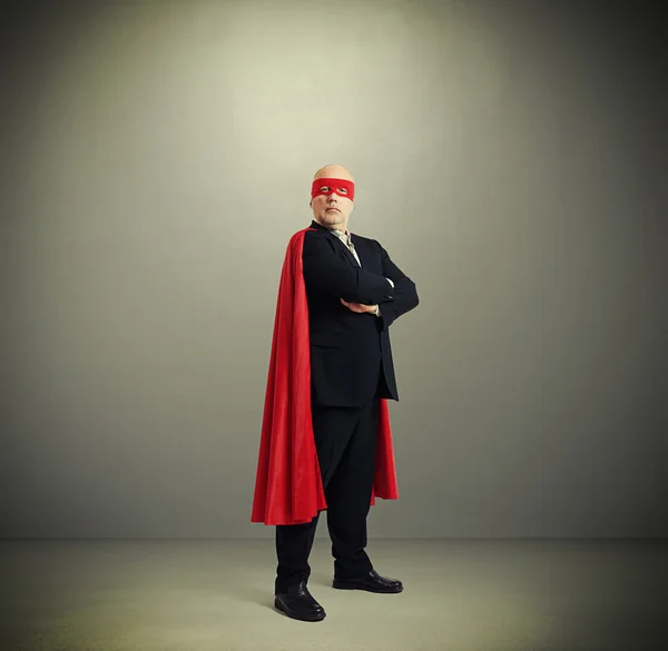 Empresário sênior assegurado vestindo como super herói — Fotografia de Stock