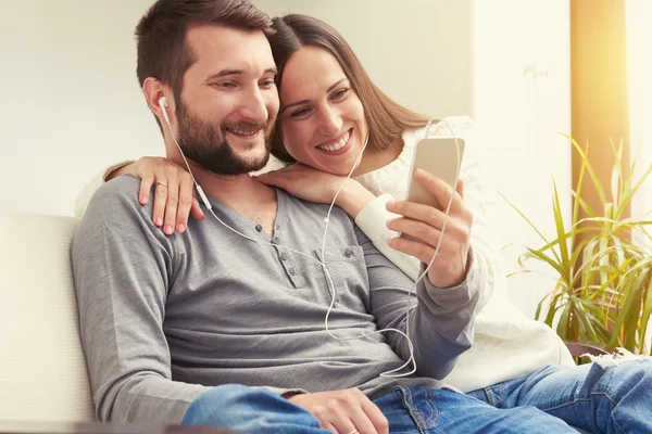 Paar zittend op een bank en luisteren — Stockfoto