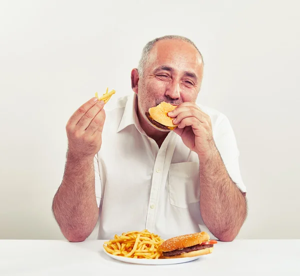 Ddle-aged hombre comer hamburguesa —  Fotos de Stock