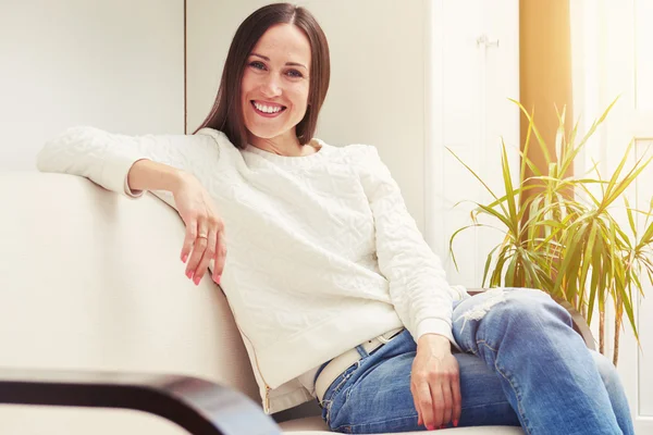 Mujer sentada en el sofá — Foto de Stock