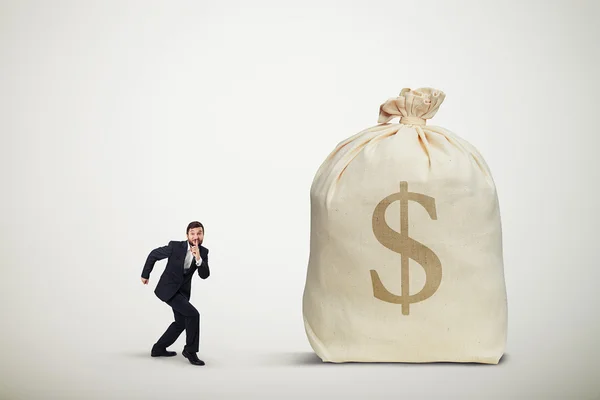 Man sneaking to the big bag of money — Stock Photo, Image