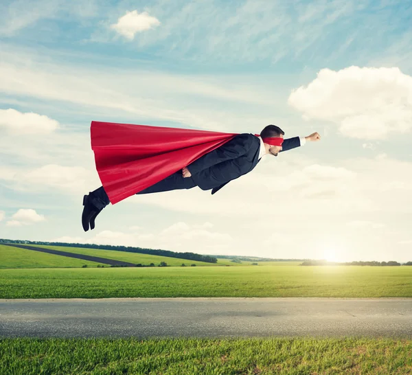 Homem vestido como um super-herói voando — Fotografia de Stock