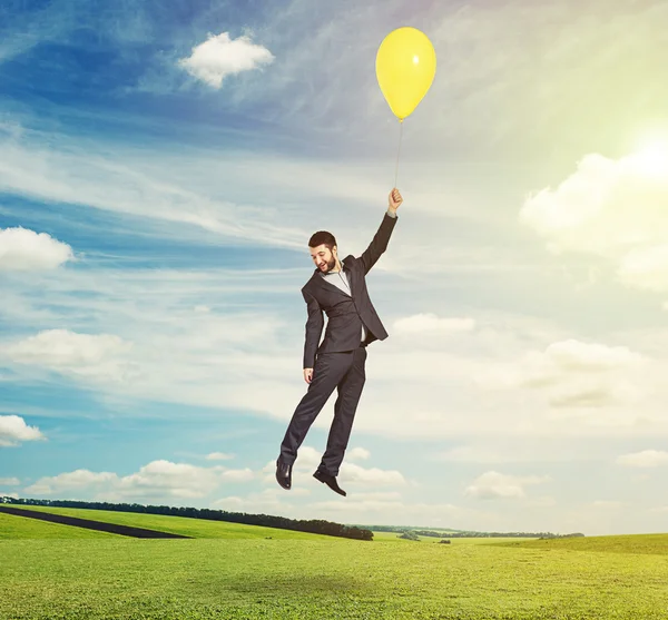 Hombre volador con globo amarillo —  Fotos de Stock