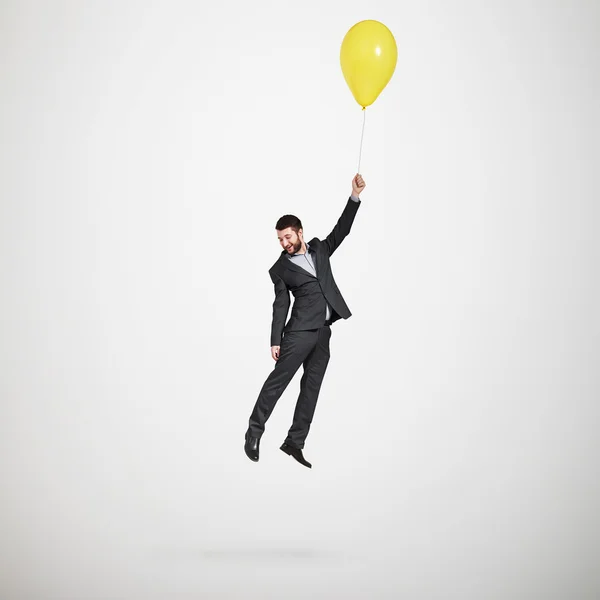 Hombre volando con globo amarillo —  Fotos de Stock