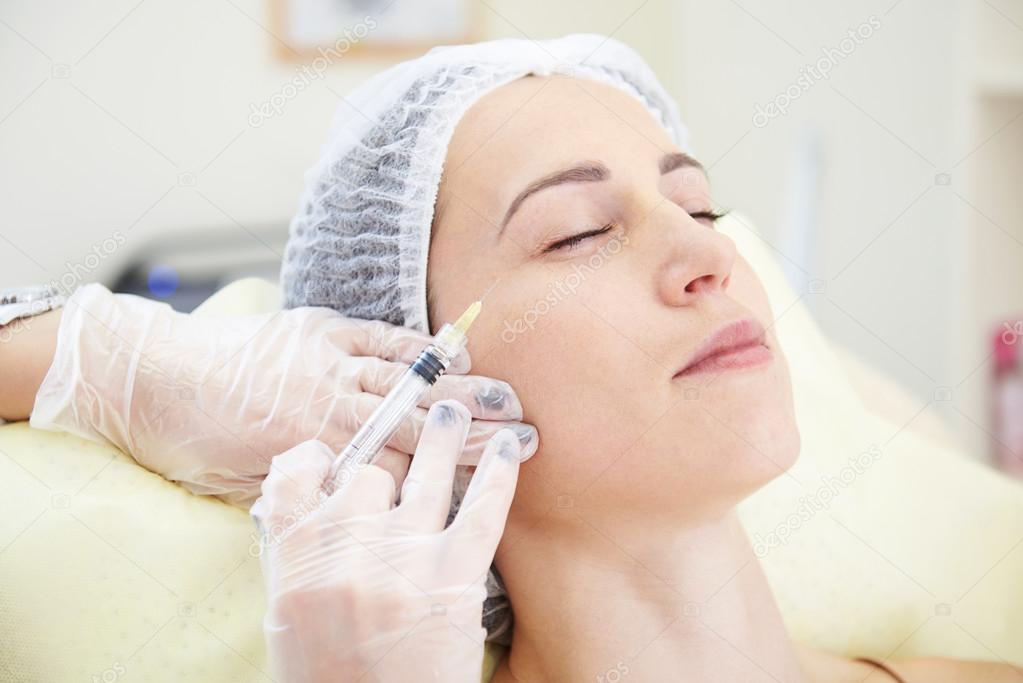woman getting an injection in her face