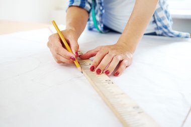 female hands with pencil and ruler