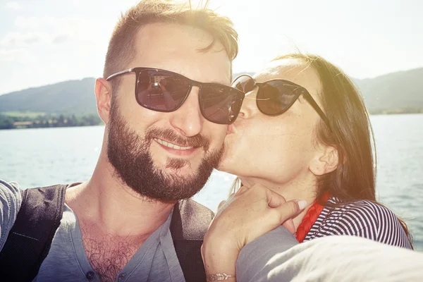 Kissing couple taking selfie — Stockfoto