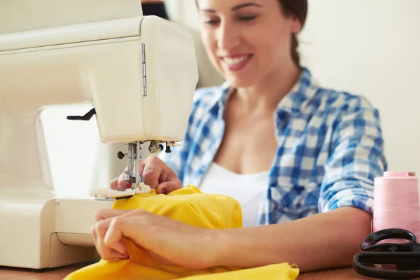 Seamstress sewing yellow dress — Stok fotoğraf