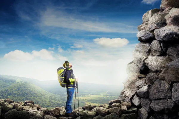 Tourist with hiker poles looking up — Stock fotografie