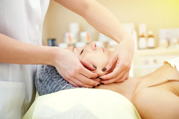 Woman getting facial massage and relaxing — Stok fotoğraf