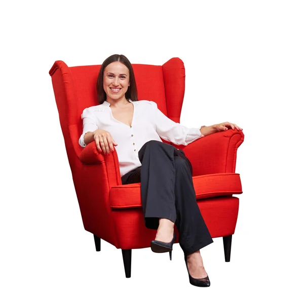 Жінка в офіційному одязі сидить на червоному стільці — стокове фото