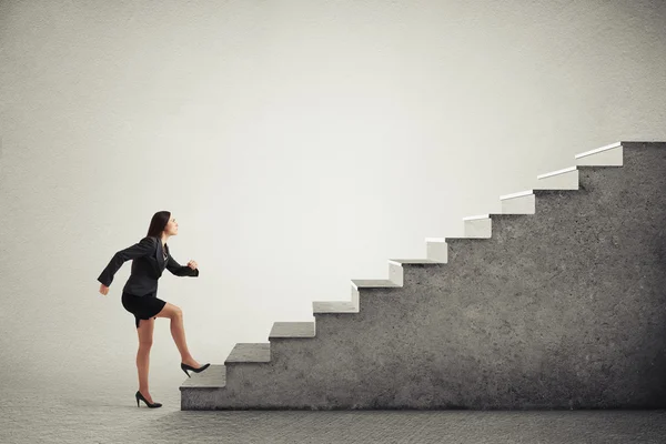 Женщина в формальной одежде поднимается по лестнице — стоковое фото
