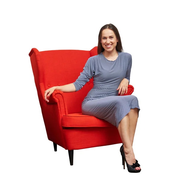 Woman in dress sitting on red chair — Stock Photo, Image