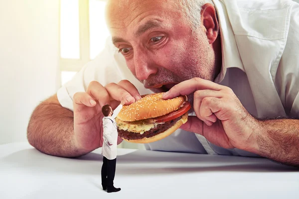 Starší muže jíst hamburger — Stock fotografie