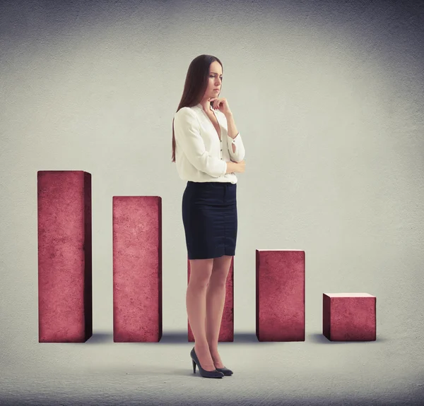 Despondent woman standing over diagram — Stock Photo, Image