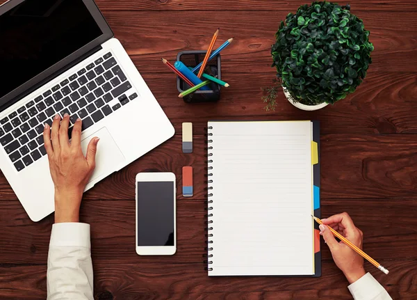 Woman typing on laptop and holding pencil — Stock Photo, Image