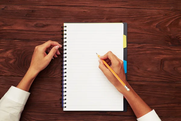 Manos de las mujeres con cuaderno en la mesa Imagen De Stock