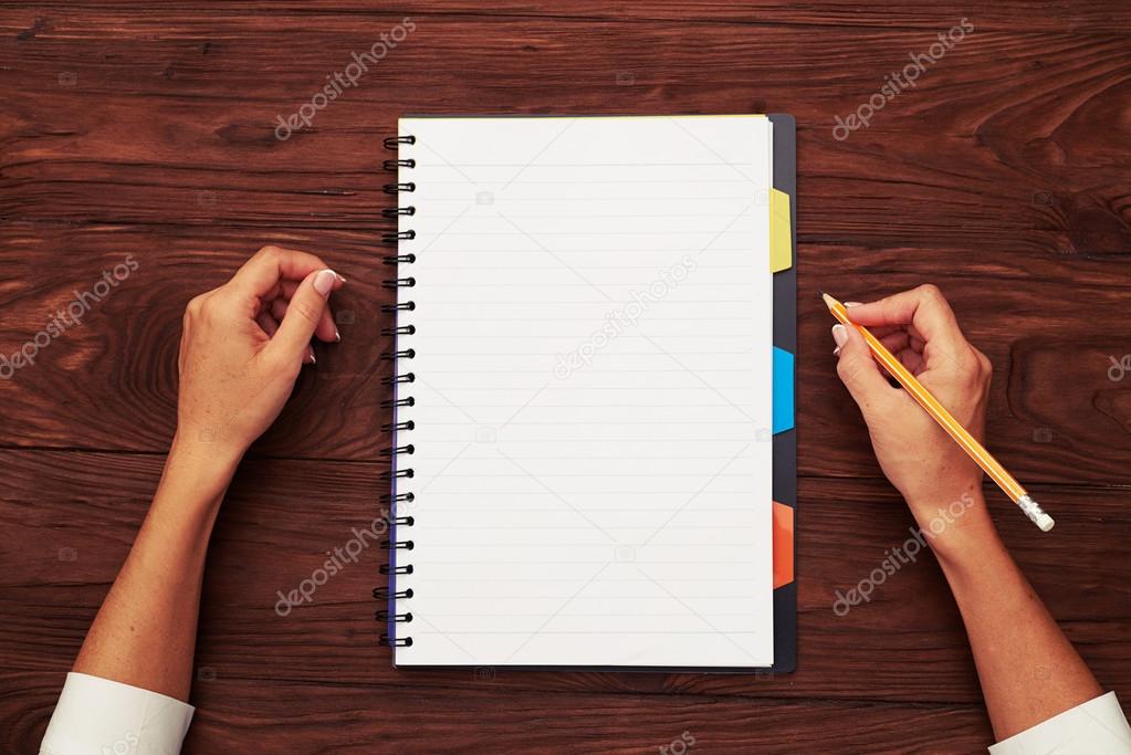 notepad and pencil in womans hand