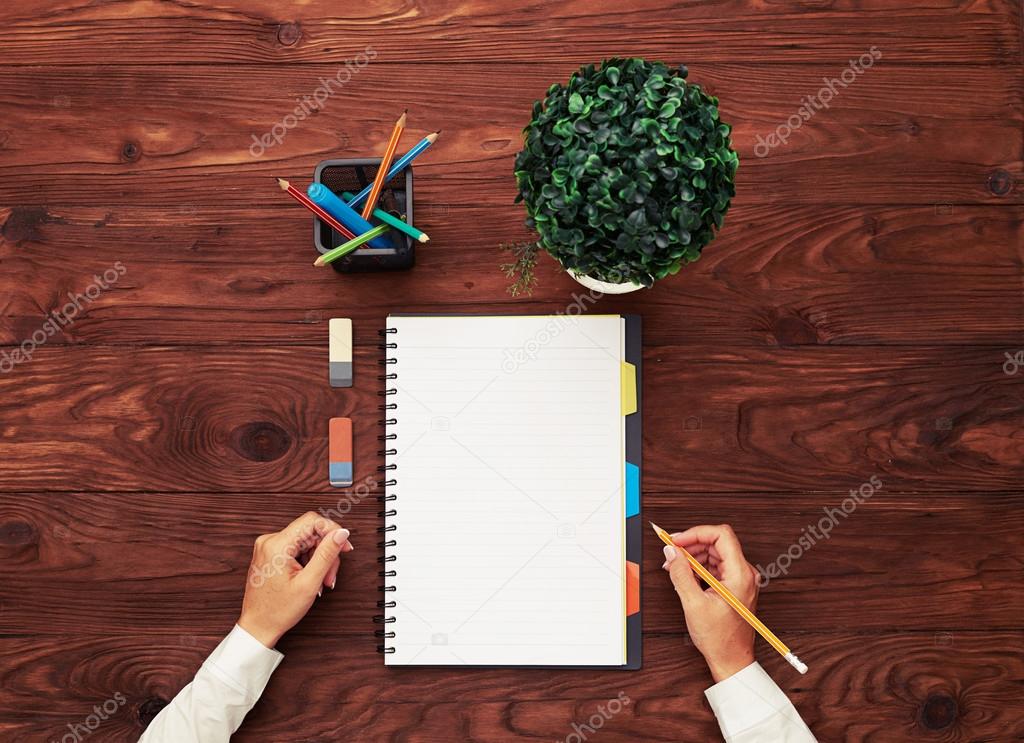 womans hands and empty white notebook