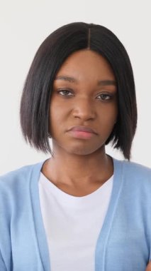 Hoşnutsuz bir Afrikalı Amerikalı kadının portresi somurtuyor ve şüphecilik gösteriyor. Sinirli ve yargılayıcı görünüyor. Beyaz arka planda soyutlanmış..