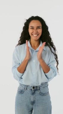 Alkışlayan ve alkışlayan neşeli genç bir kadın. Minnettarlığını, minnettarlığını ya da umudunu beyaz arka planda gösteren mutlu bir kadın modeli..