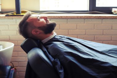 sandalyede oturan sakallı