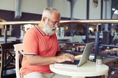 Kafede dizüstü bilgisayar ile çalışan adam