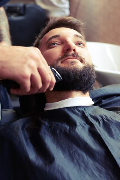 Barber shaving beard with electric razor — Stock Photo, Image