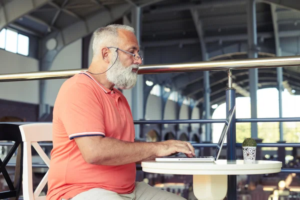 Knappe man met laptop in café — Stockfoto