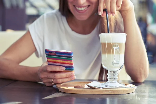 Gelukkige vrouw zitten in cafe met smartphone — Stockfoto