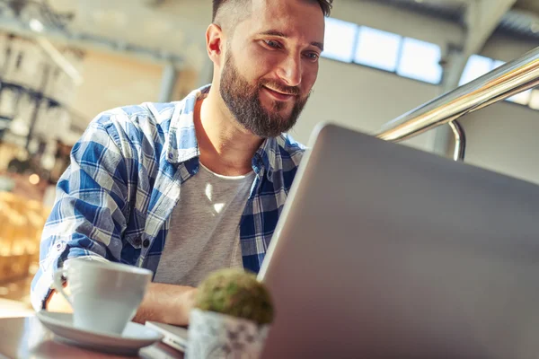 Mann macht Kaffeepause und arbeitet mit Laptop — Stockfoto