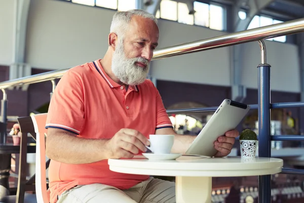 Senior man met koffie nieuws lezen — Stockfoto